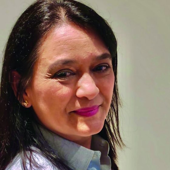 Iza Claudia, autora do livro, sorrindo em retrato